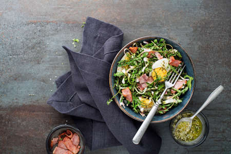 Dandelion salad with eggs and bacon on grey backgroundの写真素材