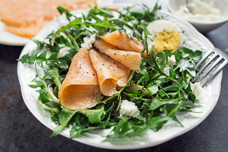 Dandelion salad with egg fresh cheese and smoked salmon close upの写真素材