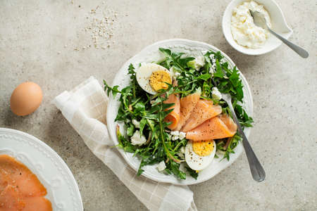 Dandelion salad with smoked salmon, egg and fresh cheeseの写真素材