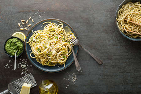 Served hot spaghetti with fresh basil pesto and parmesan cheeseの写真素材
