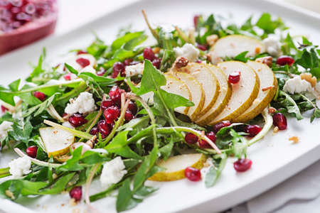 Healthy dandelion salad with pear fruit, pomegranate and fresh cheese close upの写真素材