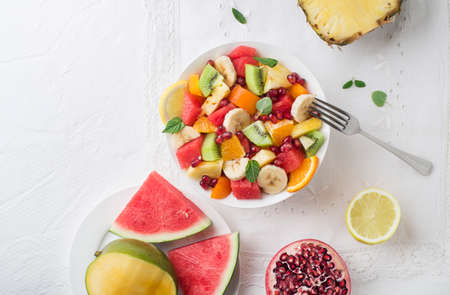 Bowl of healthy fresh fruit salad on white background, top viewの写真素材