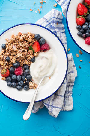 A plate of dry granola served with fresh berry fruit and yogurt. Oatmeal plate. Healthy food, diet....