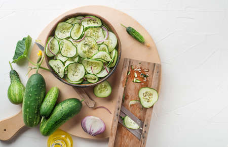 Cucumber salad. Preparation of fresh cucumber salad on white backgroundの写真素材