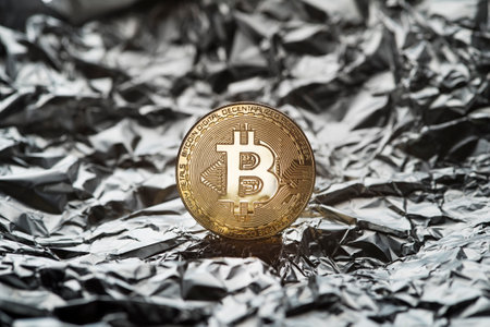 Golden coin with bitcoin symbol close up. Bitcoin and cryptocurrency investing concept. Bitcoin cryptocurrency coin on silver background. Trading on the cryptocurrency exchange. Trends in bitcoin exchange rates.の写真素材
