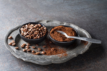Coffee beans and freshly ground coffee powder on grey stone background close upの写真素材