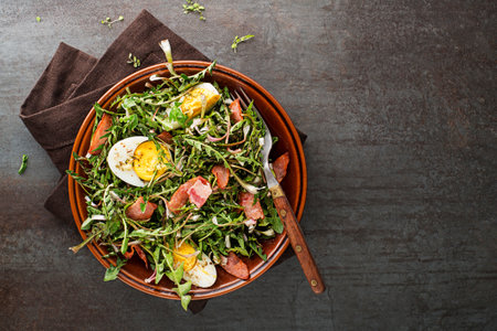 Dandelion salad with eggs and roasted bacon on grey backgroundの写真素材