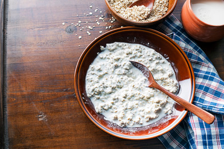 Oatmeal breakfast plate. Cooked oatmeal served with fresh milk. Healthy food, diet.の写真素材