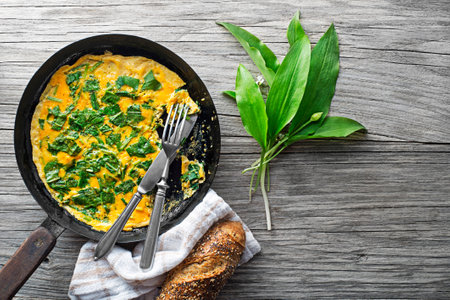 Spring omelette with fresh ramson or wild garlic leaves. Healthy spring diet food concept.の写真素材