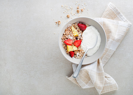 A plate of dry granola served with fresh fruit and yogurt. Oatmeal plate. Healthy food, diet. Top view.の写真素材