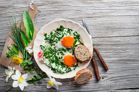 Fried eggs with fresh spring plants and herbs. Healthy spring diet food concept.の写真素材