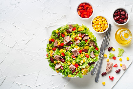 Healthy Green salad with tuna, corn, red pepper and beans on white table background. Mexican corn salad.の写真素材