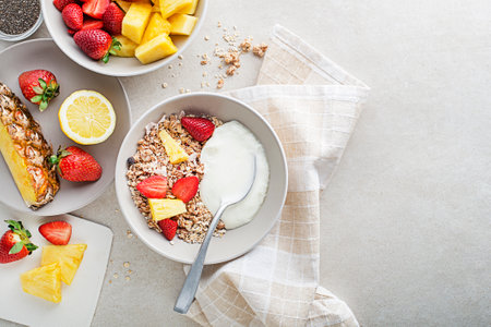A bowl of dry granola served with fresh fruit and yogurt. Oatmeal plate. Healthy food, diet. Top view.の写真素材