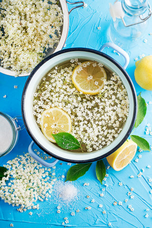 Process of making a summer drink, made from natural fermentation of elder flowers in water lemon and sugar. Preparation of an elder flower syrup from fresh elder flowers, honey, and lemonの写真素材