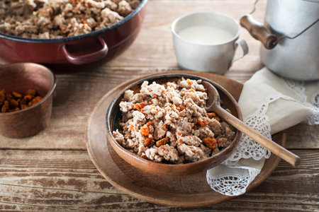 Slovenian traditional dish buckwheat mush served with pan-fried pork cracklings and lard and bowl warm milkの写真素材