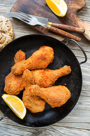 Fried crispy chicken legs, drumstick in a pan. Top view. Crispy, golden-brown fried chicken drumstickの写真素材