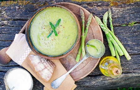 Asparagus cream soup in a rustic bowl on wooden backgroundの写真素材
