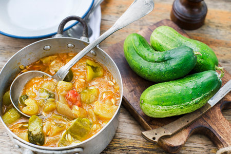Eating Slovenian traditional dish with cucumber sauce in red. Freshly picked cucumbers from the garden. Summer foodの写真素材