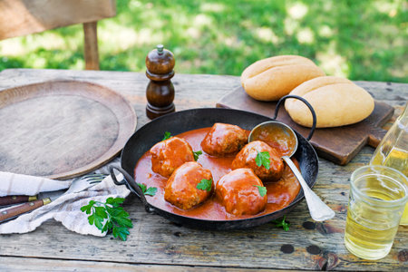 Fried meatballs braised in tomato sauce served in garden. Eating Beef roasted meatballs in tomato sauce.の写真素材