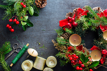 Making Advent wreath from natural branches of spruce, juniper and holly red berries. Decorations for christmas wreath at homeの写真素材