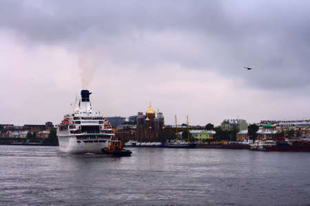 Big ship - nautical liner with towboat turn around at the river Neva and sail awayの写真素材