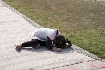 Little girl hiding her face in the ground.の写真素材