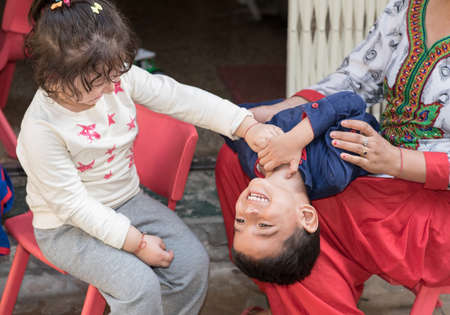 Kids having fun at home, tickling and giggle, happy family.