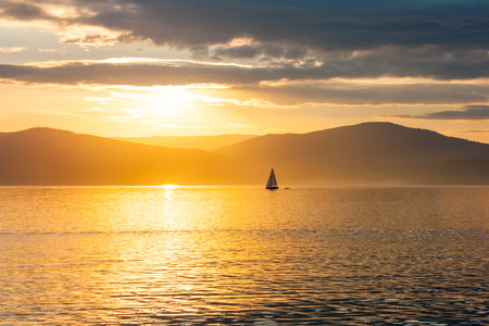Sailing ship on the lake at sunset skylineの写真素材