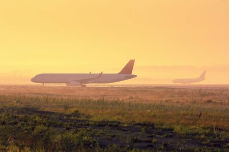 Planes on the taxiway in the early foggy morningの写真素材