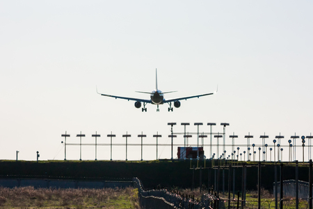 Silhouette of passenger aircraft on landing with approaching runway lightsの写真素材