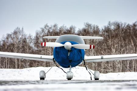Front view of the shrouded small sports airplane at the winter airfieldの写真素材