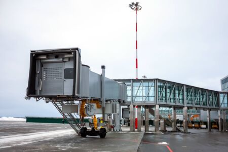 Empty passenger air bridge at the winter airport apronの写真素材