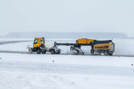 Snowblower cleans airport taxiway in a blizzardの写真素材