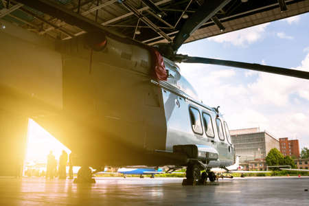 Passenger helicopter in the hangar. Rotorcraft under maintenance. Checking mechanical systems for...