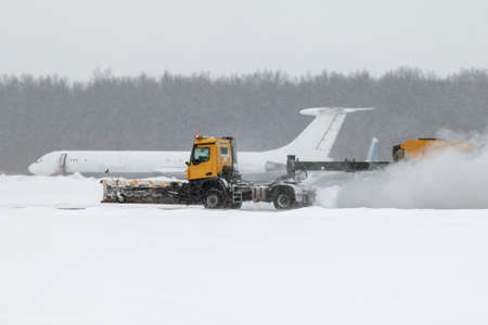 Airfield snow blower cleaning the runway at the airport in a severe blizzard