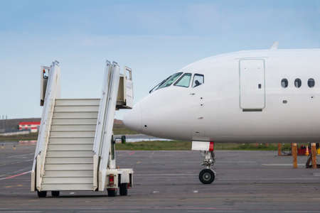 Air-stairs near the passenger jet plane on the airport apronの写真素材