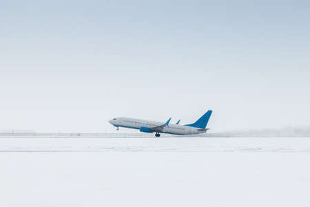 Takeoff of a passenger jet plane in a severe snowstormの写真素材