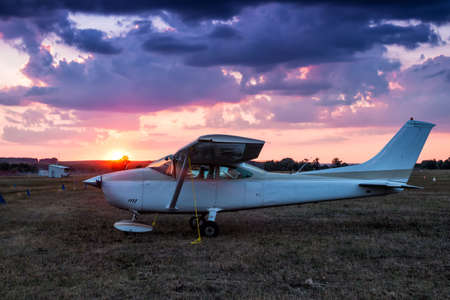 Small private airplane parked at the airfield at scenic sundown