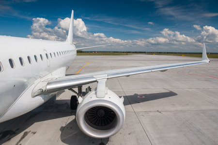White passenger airliner on the airport apron. View of the wing and rear airplaneの写真素材