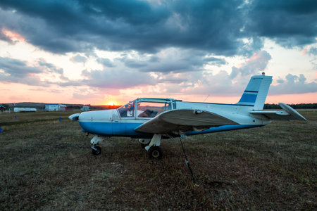 Small private aircraft parked at the airfield at picturesque sunset