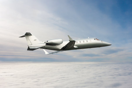 Modern luxury business jet flies in the air above the clouds