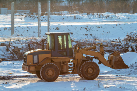 Yellow front loader wheeled tractor at a construction site at winterの写真素材
