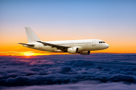 White passenger airplane fly in the sunrise skyの写真素材