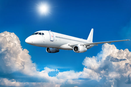 White passenger airliner fly in the air above picturesque cloudsの写真素材