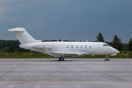 Modern white executive airplane on the airport apron on a cloudy dayの写真素材