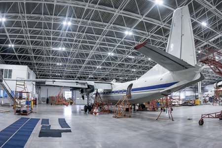 Transport turboprop airplane in the hangar. Aircraft under maintenance. Checking mechanical systems for flight operationsの写真素材