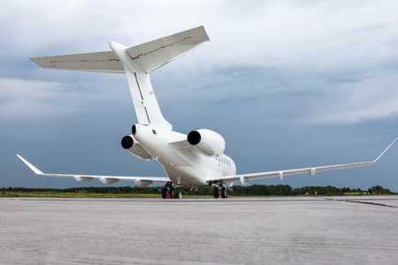 White luxury executive aircraft on the airport apron on a cloudy day