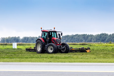 Wheel tractor with lawn mower by the roadの写真素材