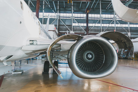 White passenger jet plane in the aviation hangar. Aircraft under maintenance. Checking mechanical systems for flight operationsの写真素材