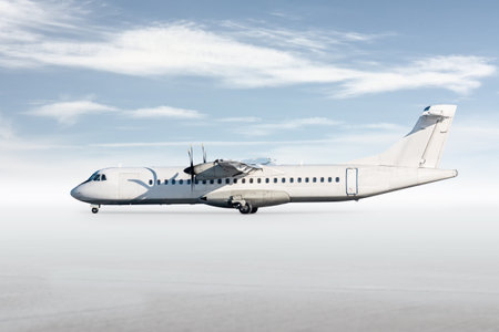 White passenger turboprop airliner isolated on bright background with sky